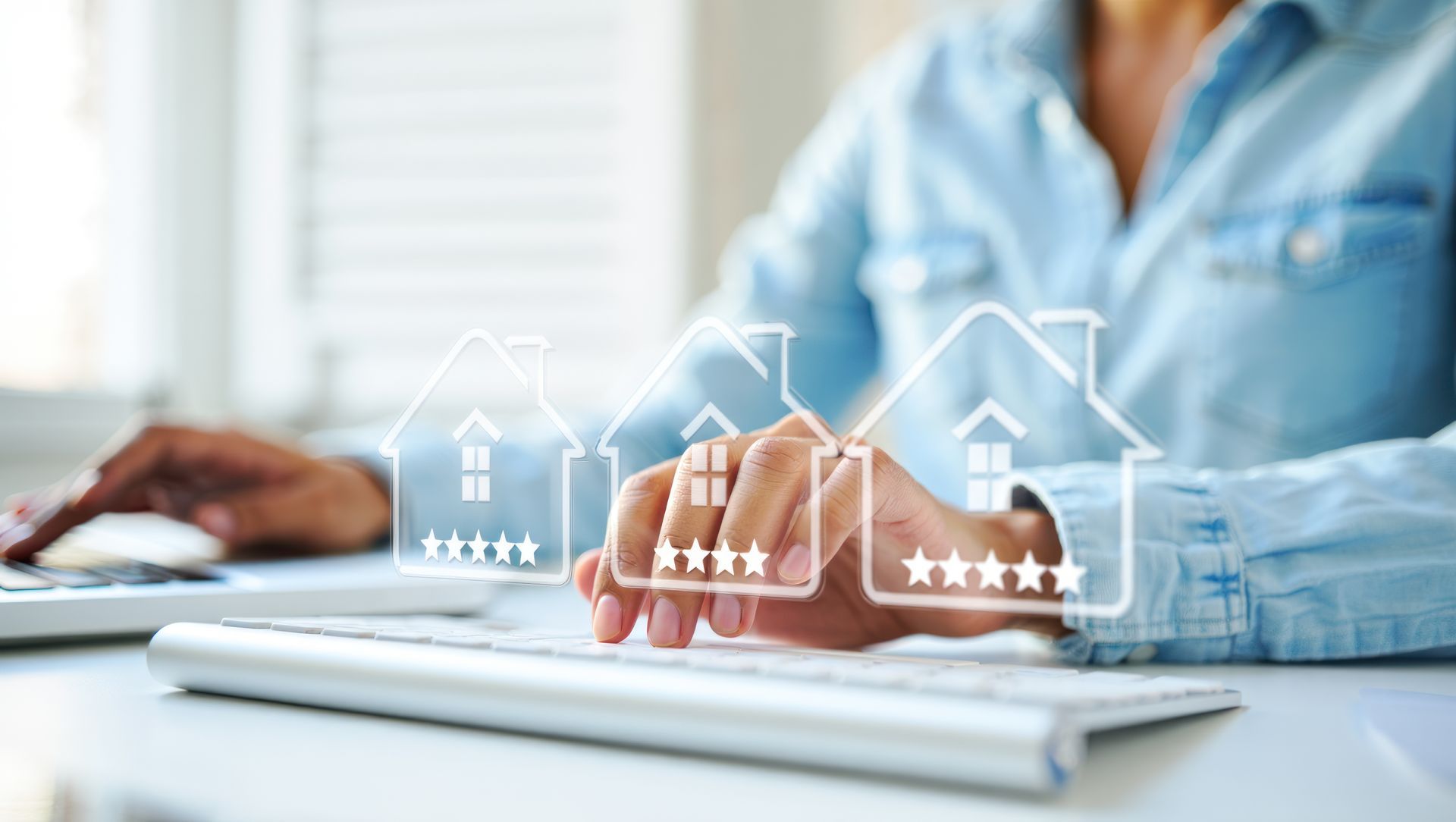 Person typing on keyboard with house rating icons overlaid.