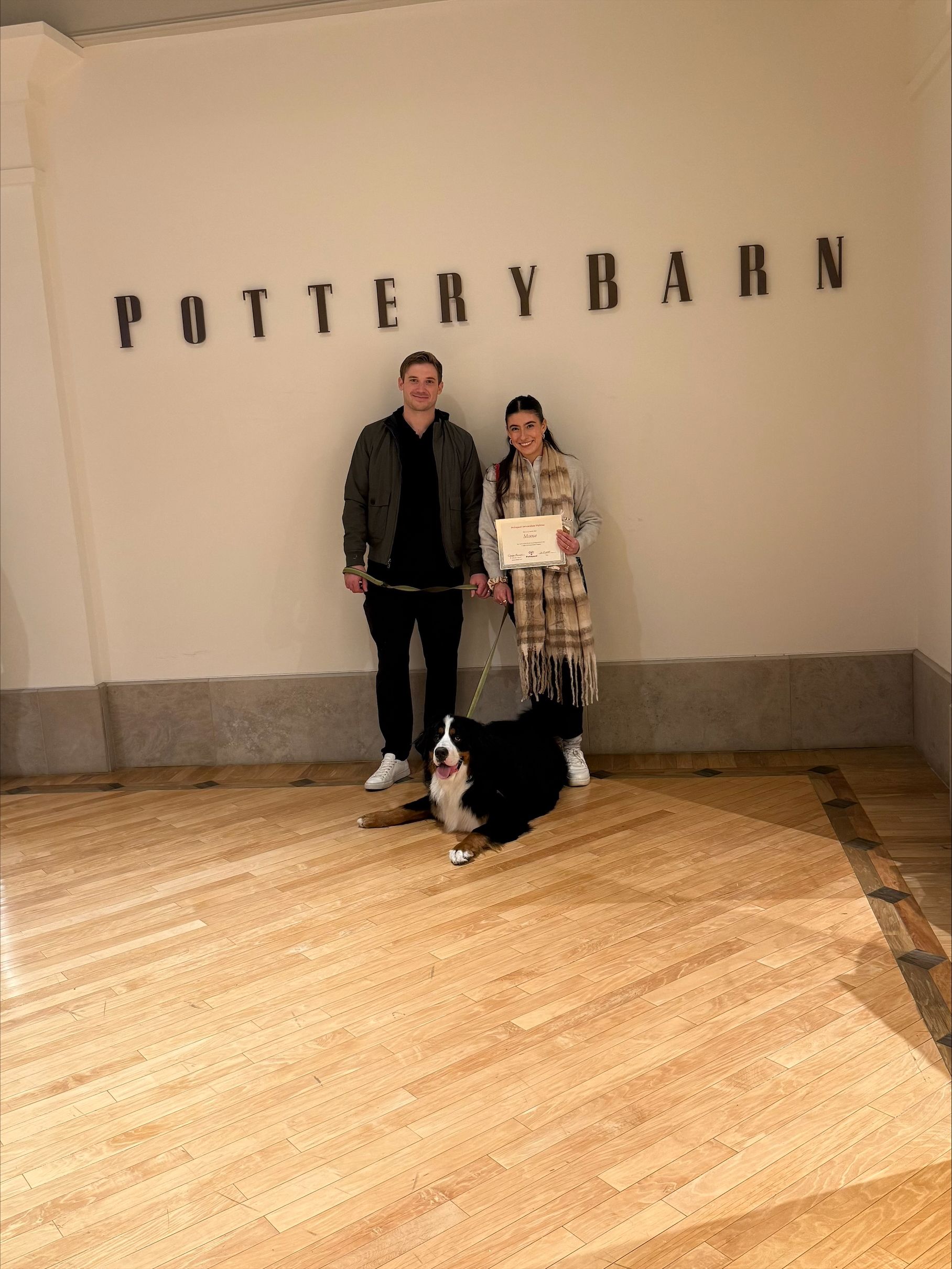 Two people and a dog posing in a Pottery Barn store