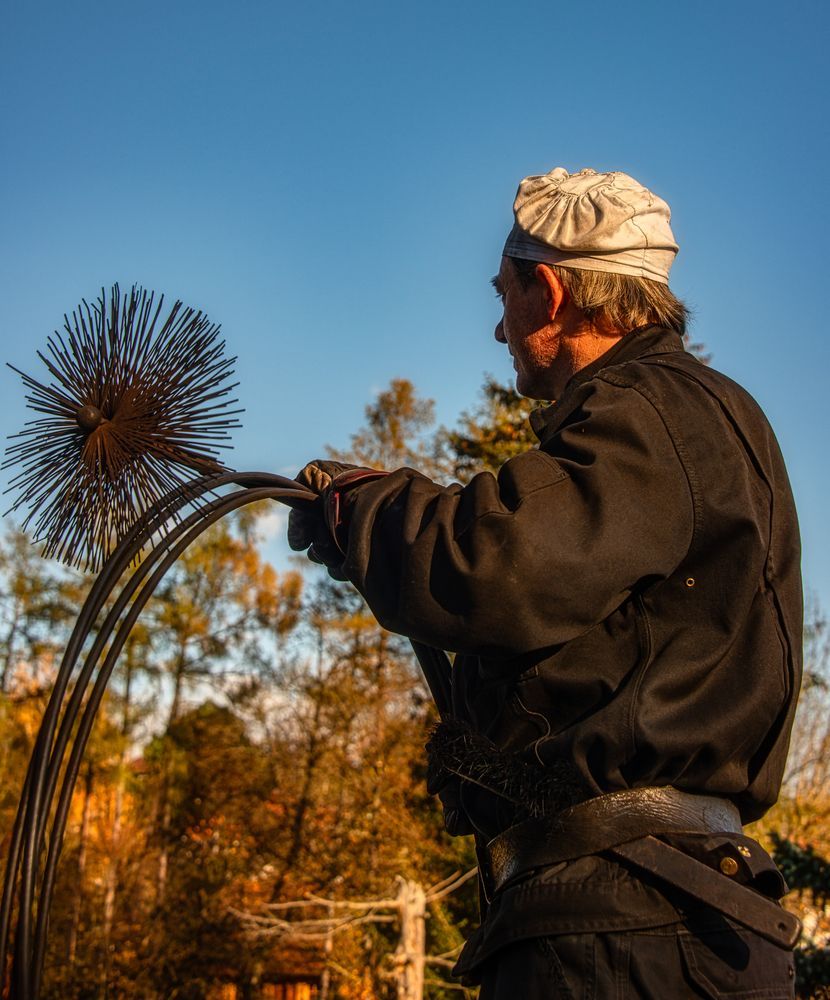 chimney cleaner holding sweep brush