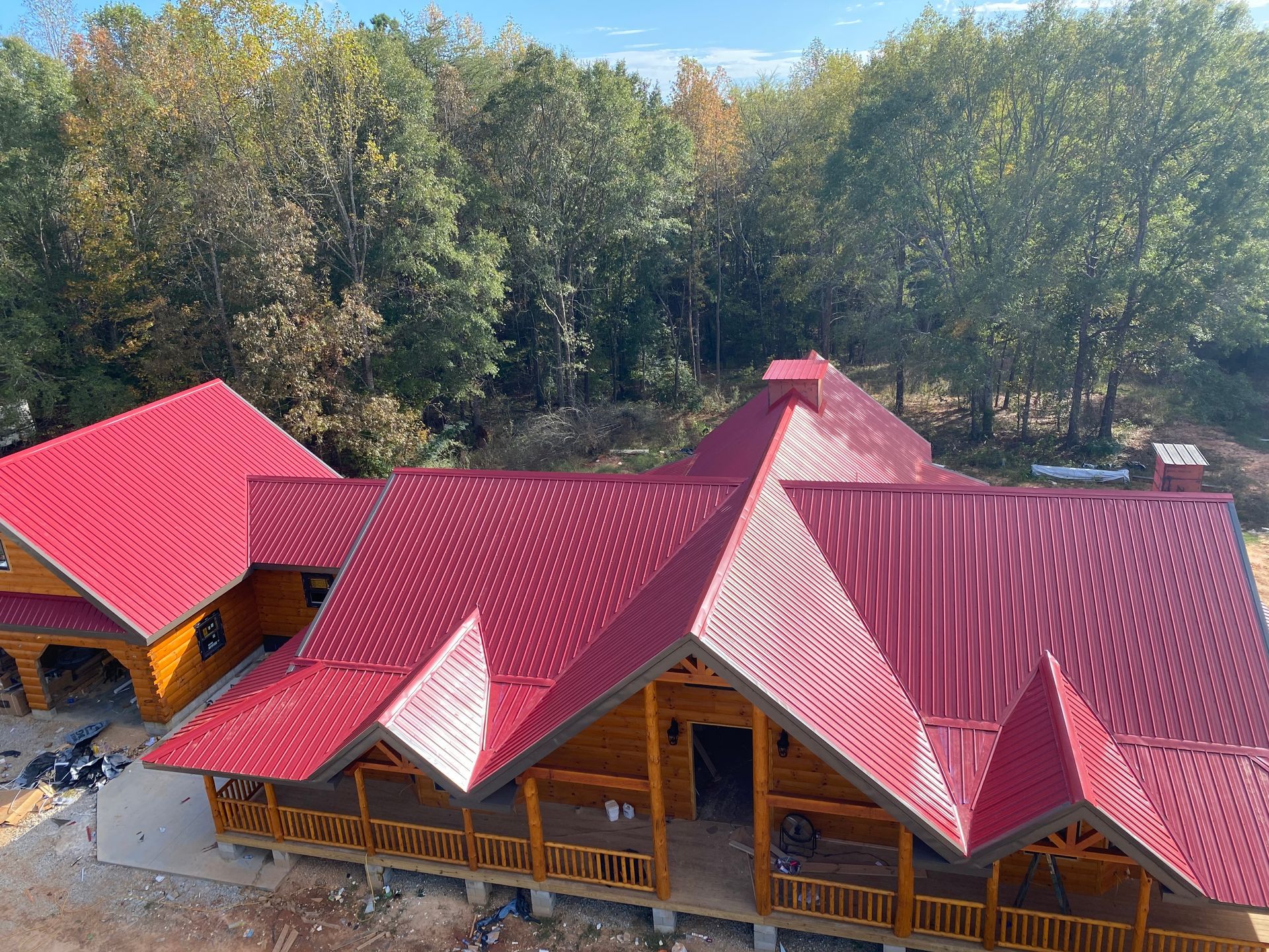 Red-roofed wooden lodge buildings surrounded by trees, viewed from above