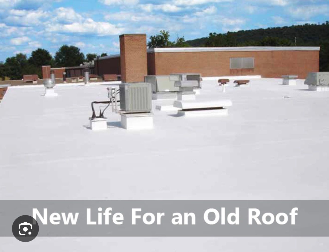 Flat white roof with HVAC units on a brick building under a blue sky; text reads “New Life For an Old Roof”