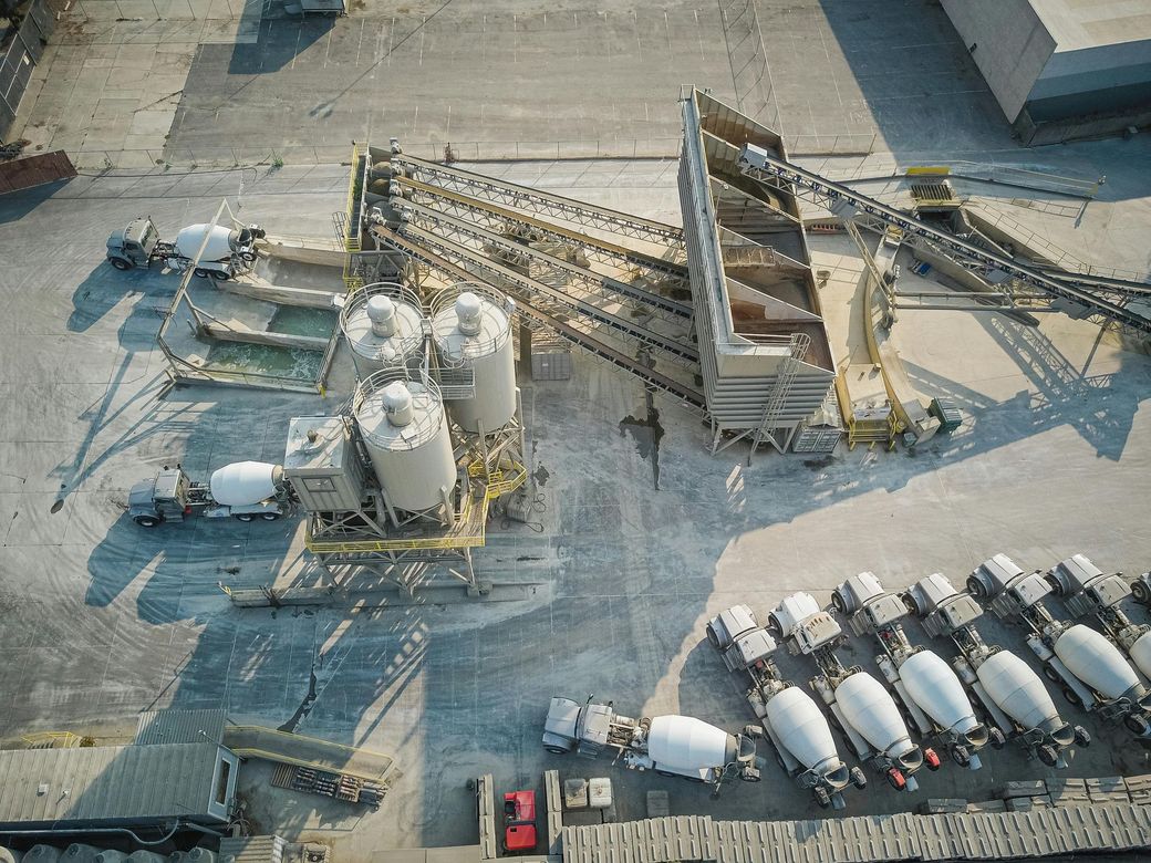 An aerial view of a concrete plant with trucks and silos.