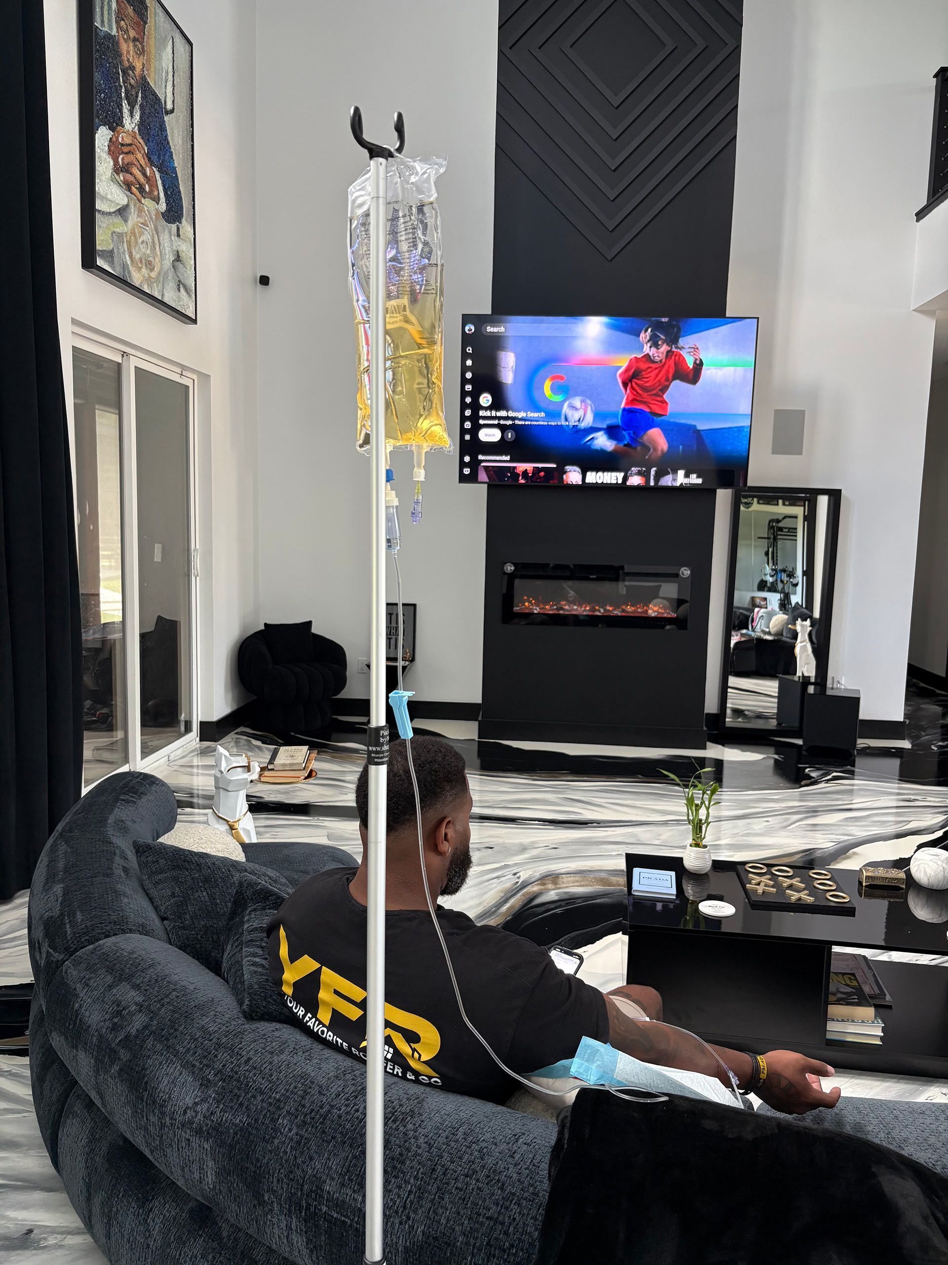 Living room with a TV showing Spider-Man, a person seated on a couch, and a coffee table in the foreground