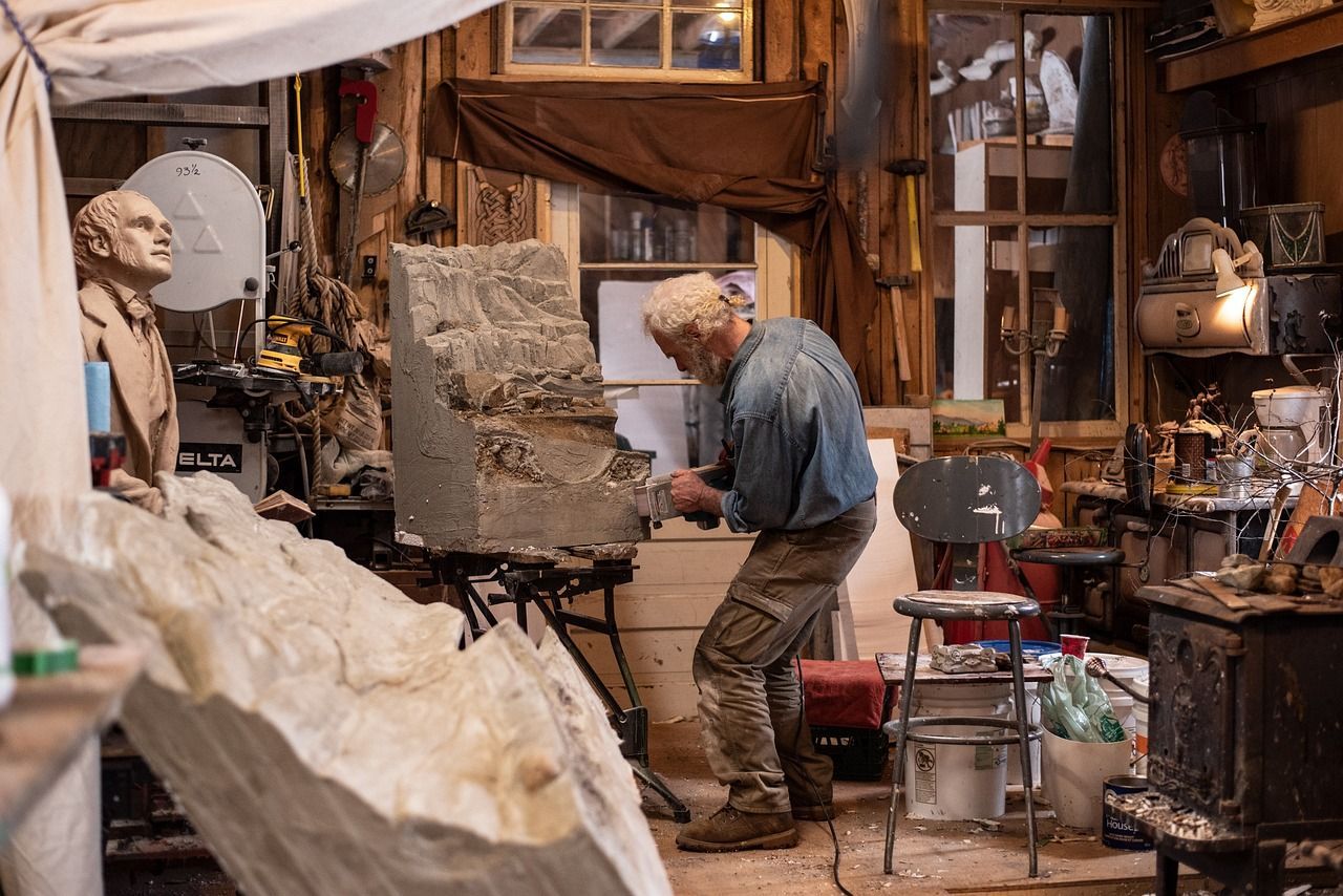 A man is working on a statue in a workshop.