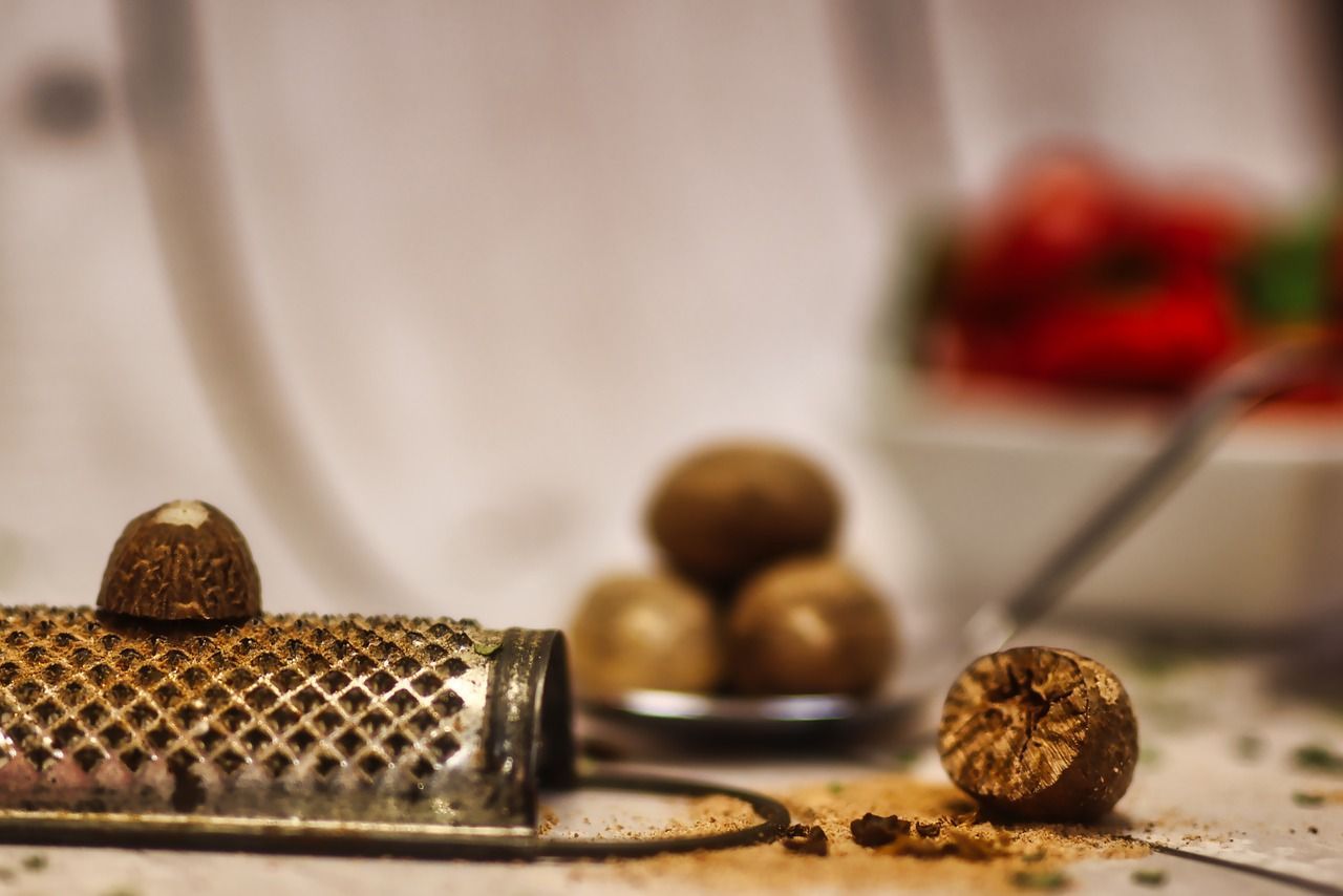 A nutmeg grater is sitting on a table next to a nutmeg.