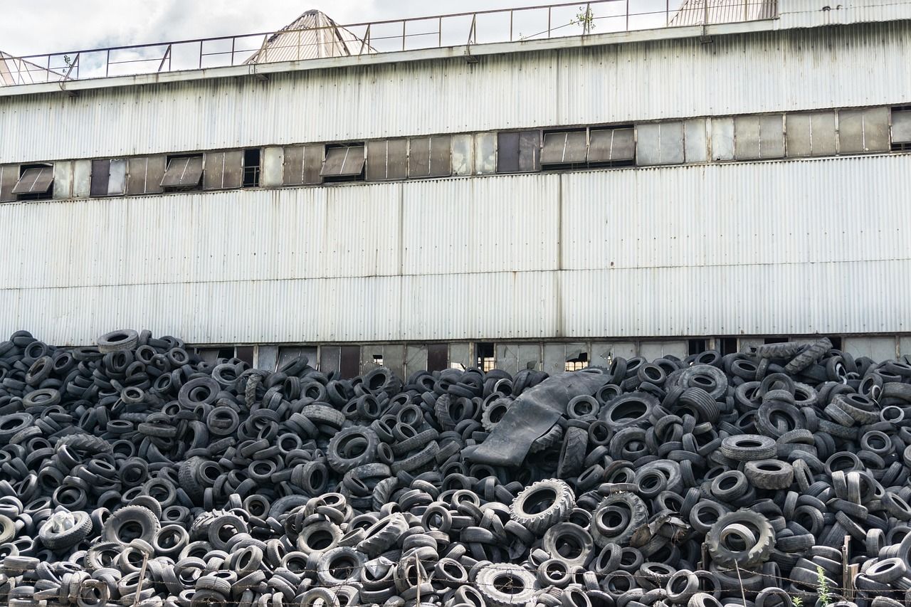 A pile of old tires is sitting in front of a building.