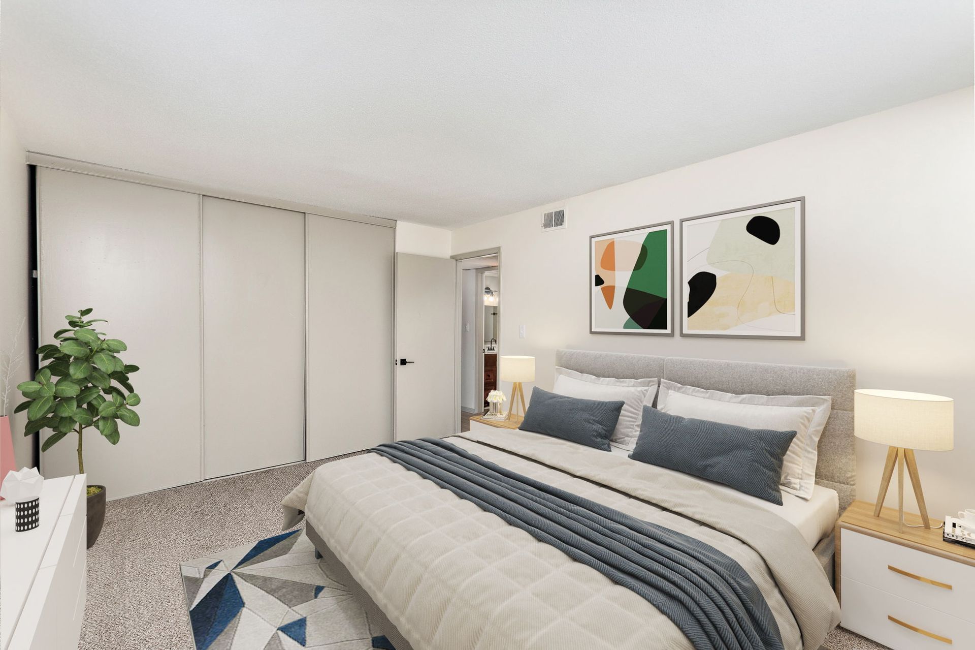 Bright bedroom with a bed, striped bedding, white wardrobe, bedside lamp, and abstract wall art
