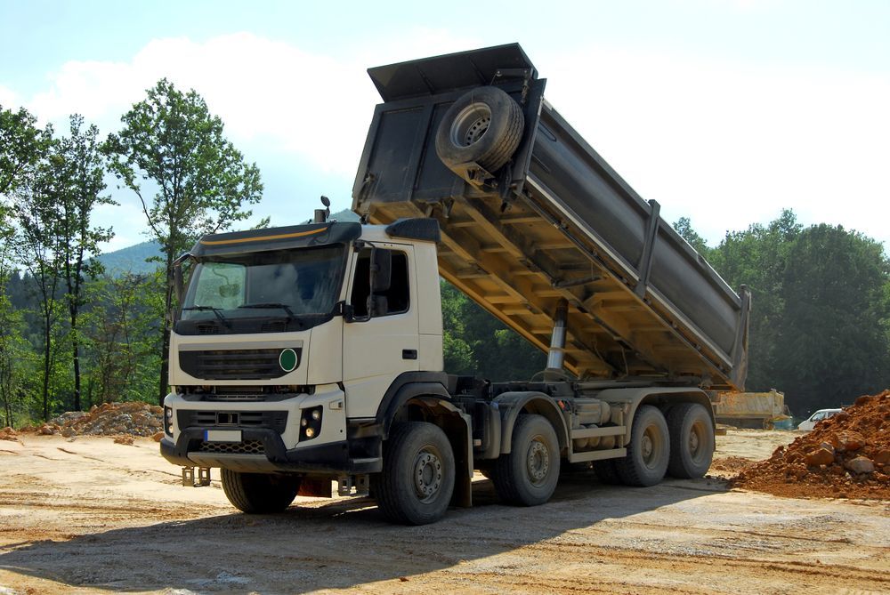 A White Dump Truck Is Parked In A Dirt Field — Dubbo Hardcore Soils & Earthmoving In Dubbo, NSW
