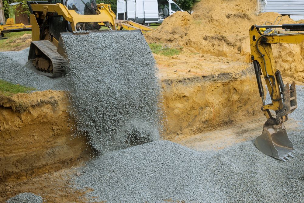 A Bulldozer Is Loading Gravel Into A Bucket On A Construction Site — Dubbo Hardcore Soils & Earthmoving In Dubbo, NSW