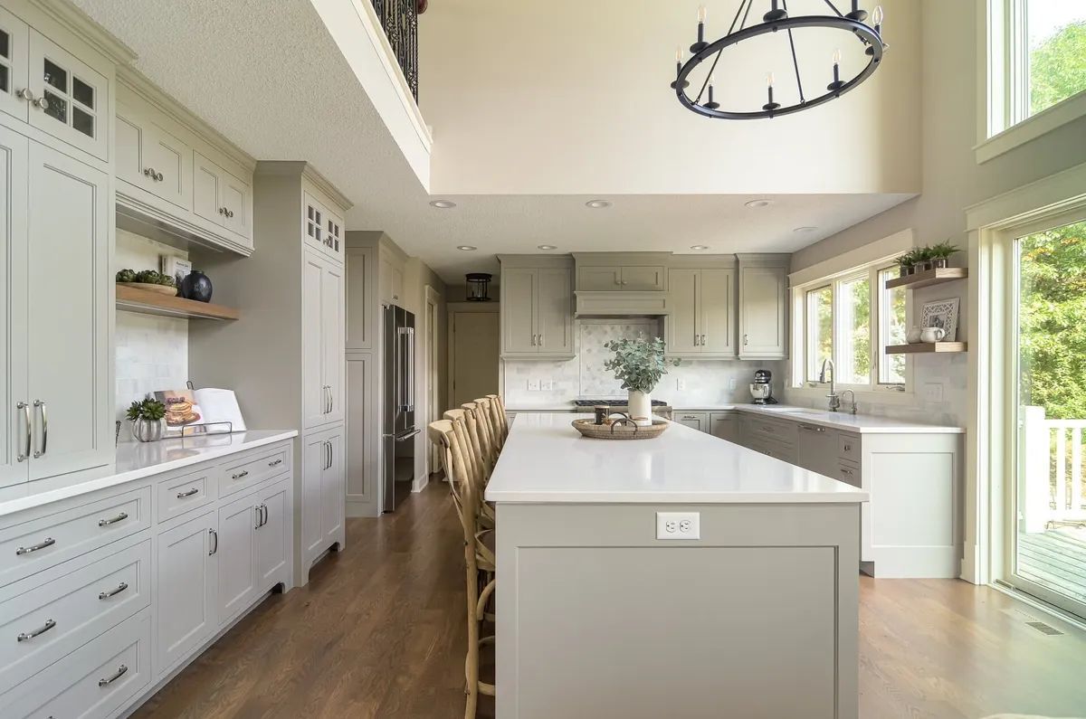 A kitchen with a large island and a chandelier hanging from the ceiling.