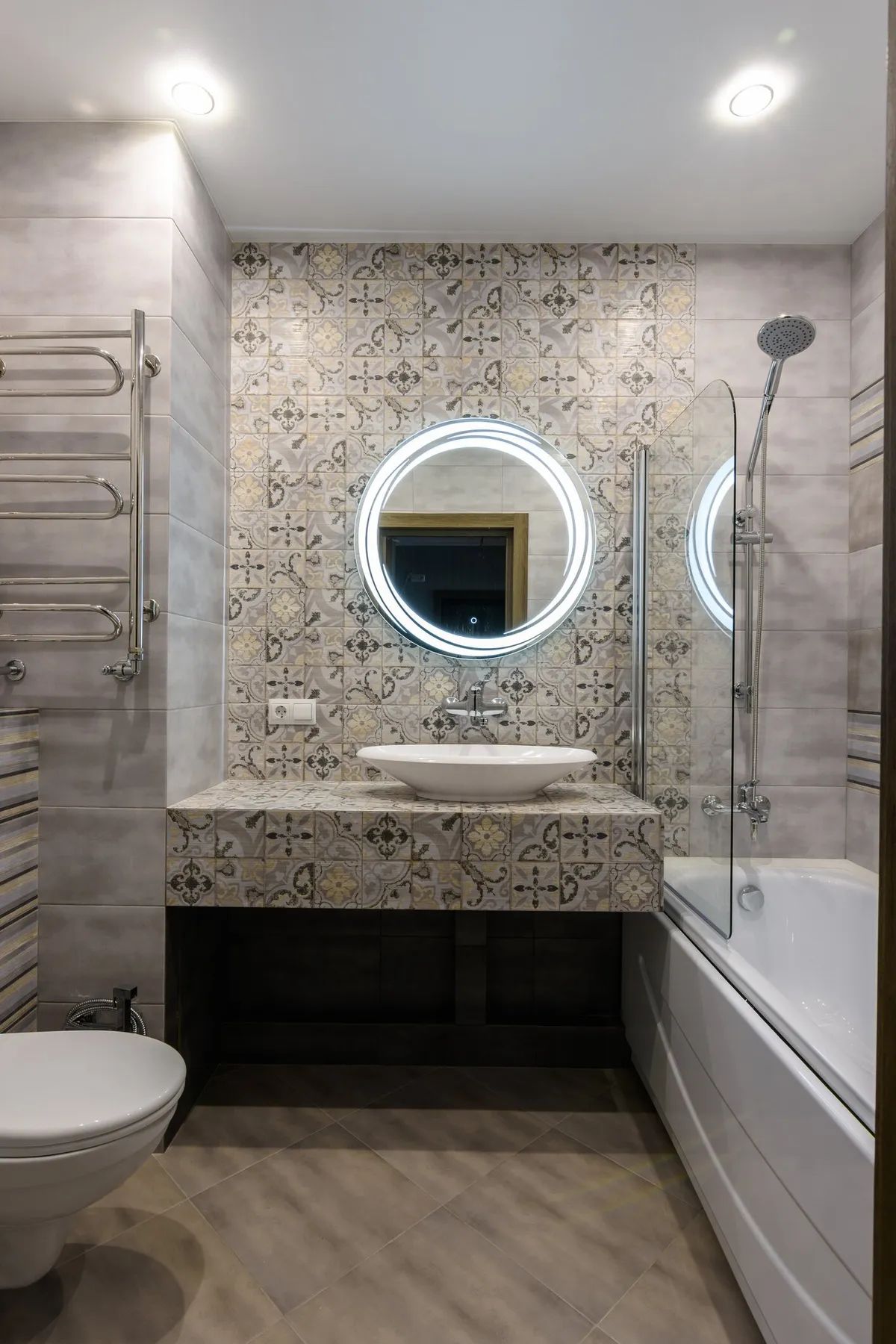 A bathroom with a toilet , sink , bathtub and mirror.