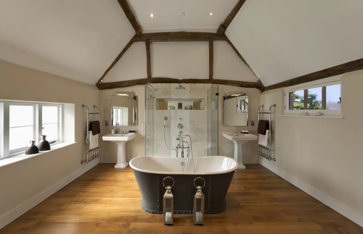 A bathroom with a bathtub , sink and shower.