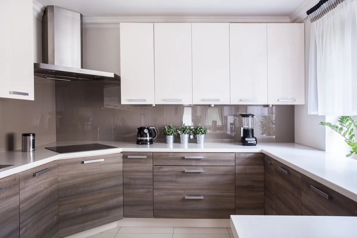A kitchen with wooden cabinets and white counter tops