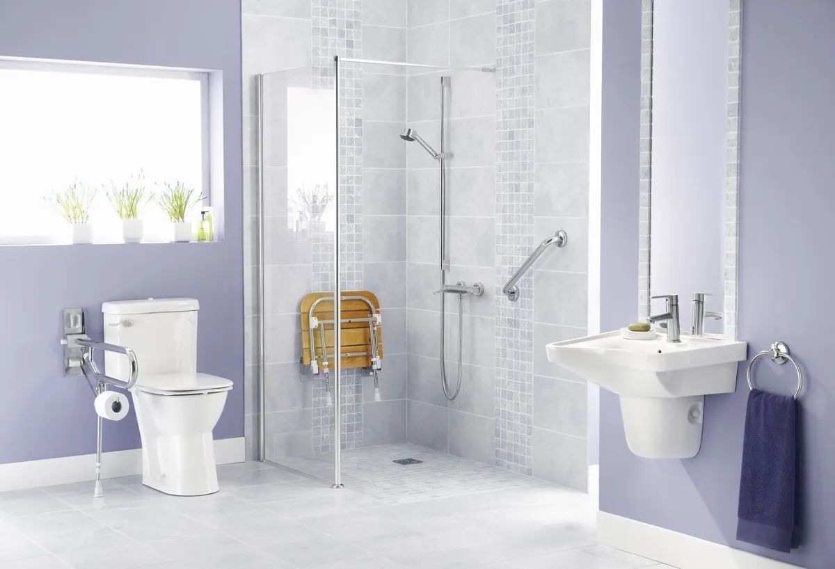 A bathroom with a toilet , sink , shower and window.