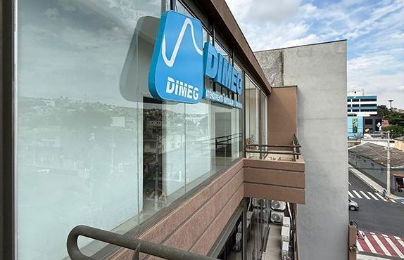 Placa azul de lanchonete na fachada de um prédio, vista de uma varanda acima da rua.