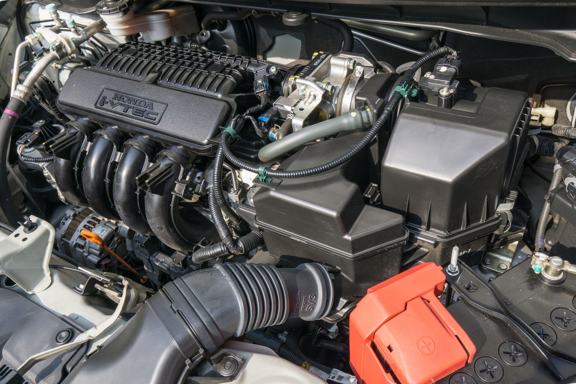 Car engine, black and silver with battery and air intake.