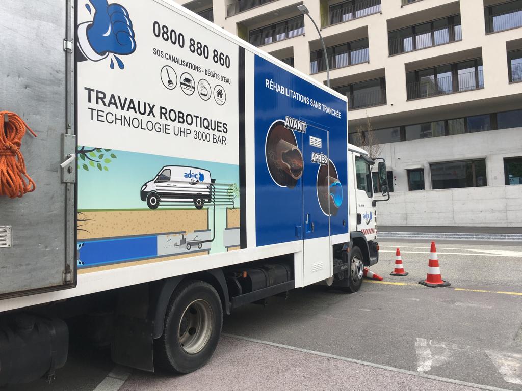 Un camion bleu et blanc est garé sur le bord de la route