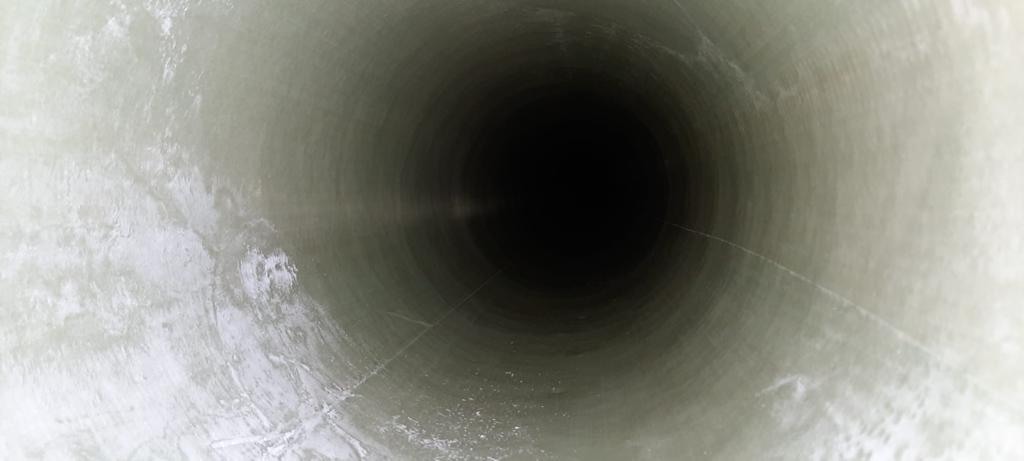 Un gros plan d'un tuyau blanc avec un trou noir au milieu.