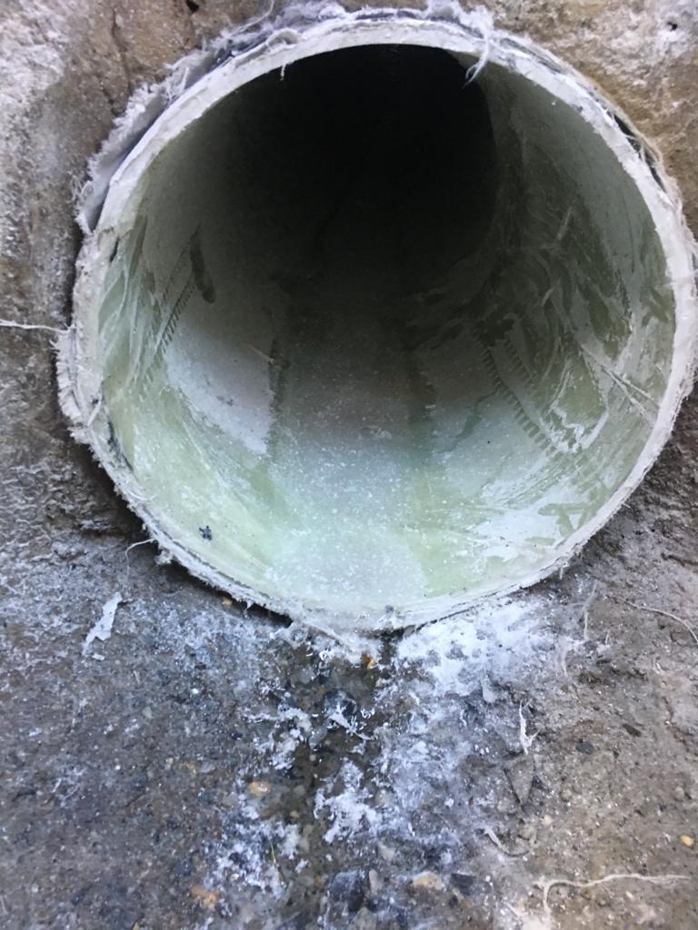 Un gros plan d'un tuyau sortant d'un trou dans le sol.
