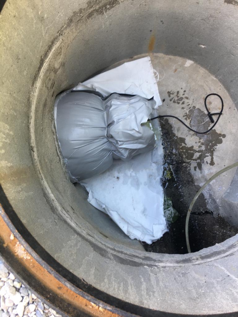 Un sac de sable se trouve à l'intérieur d'un couvercle de regard.