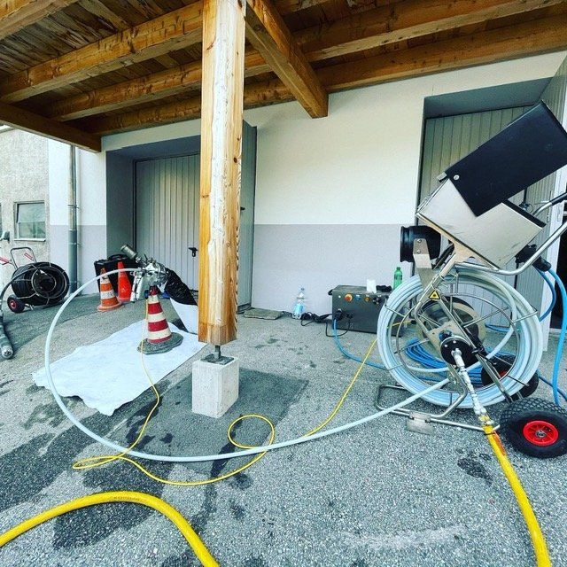 Un tas de tuyaux reliés à une machine devant un bâtiment