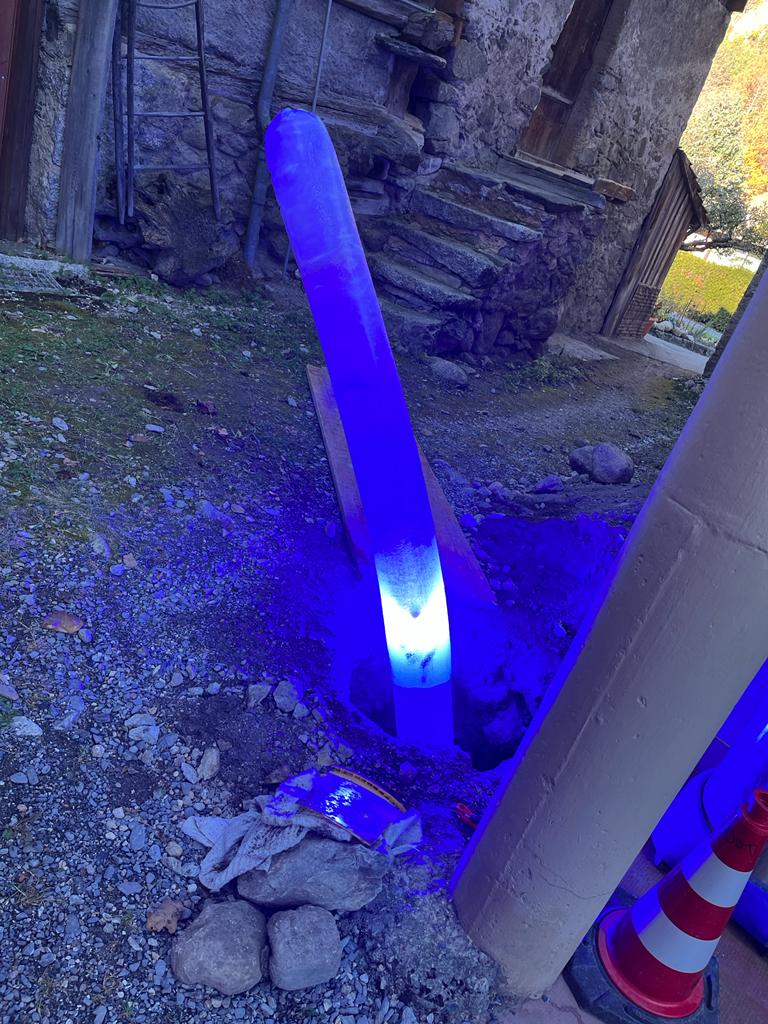 Une lumière bleue sort d'un trou dans le sol.