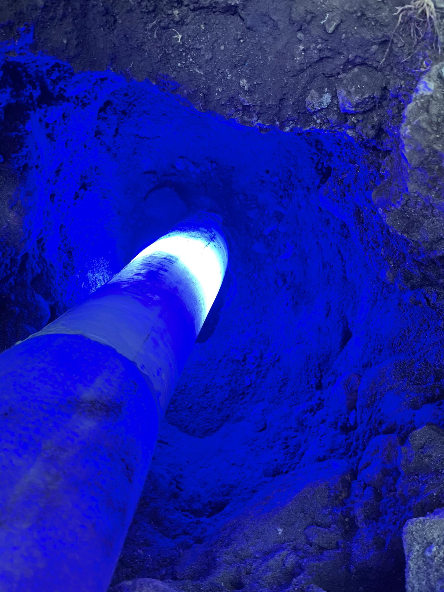 Une lumière bleue brille à travers un trou dans le sol.