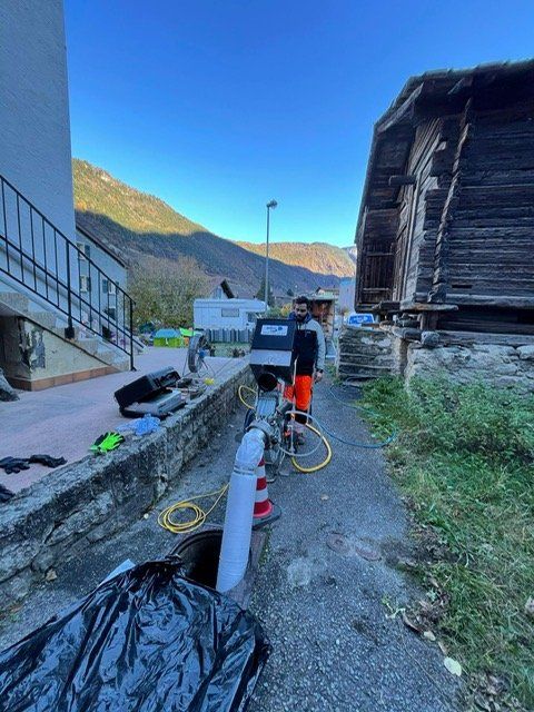 Un homme se tient sur un trottoir à côté d'un bâtiment en bois.