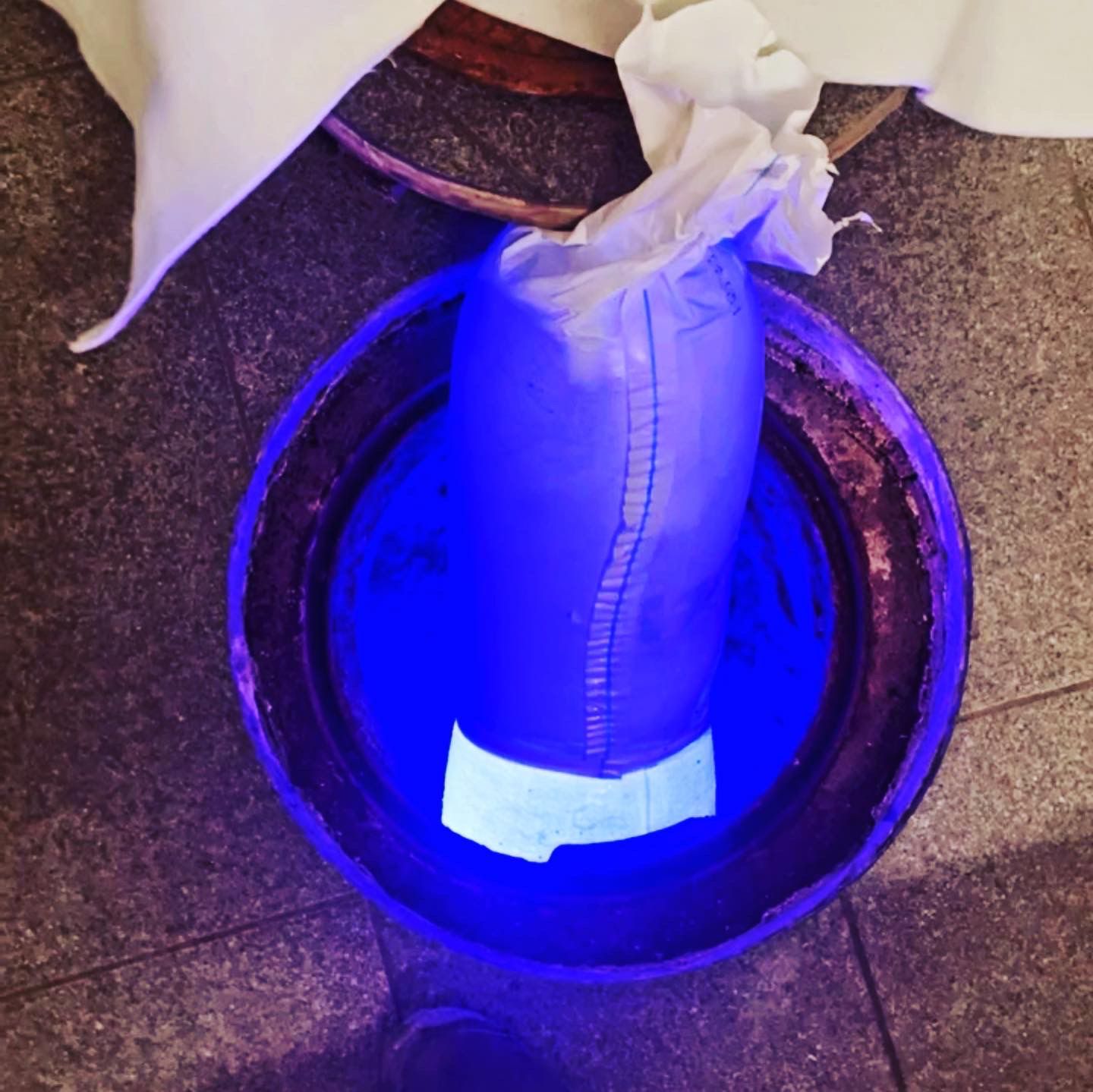 Une lumière bleue brille sur un sac dans un seau