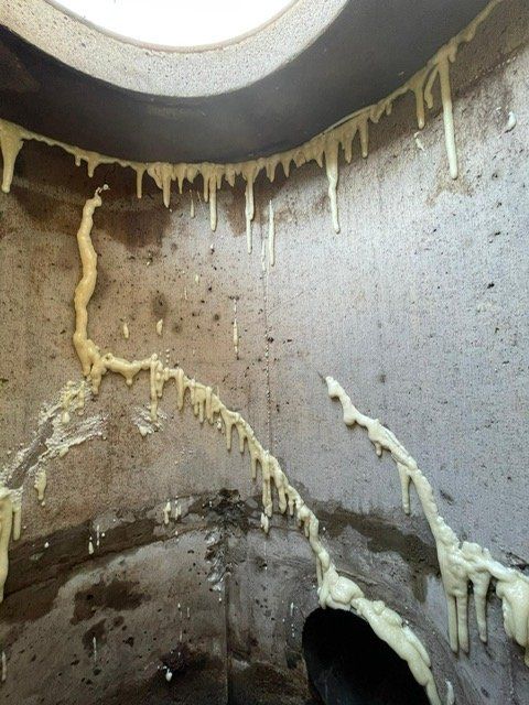 Un trou dans un mur d'où sort de la mousse