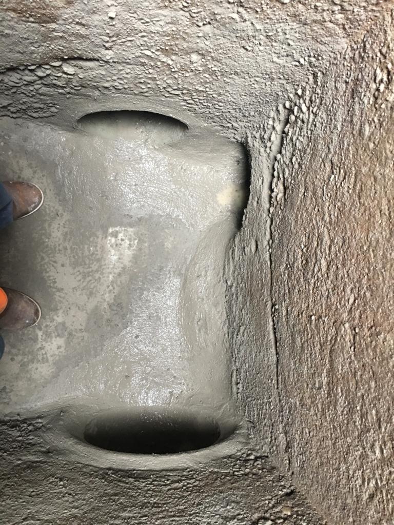 Une personne se tient à côté d'un trou dans un mur.