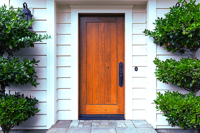 solid wood front door with black hardware and white trim