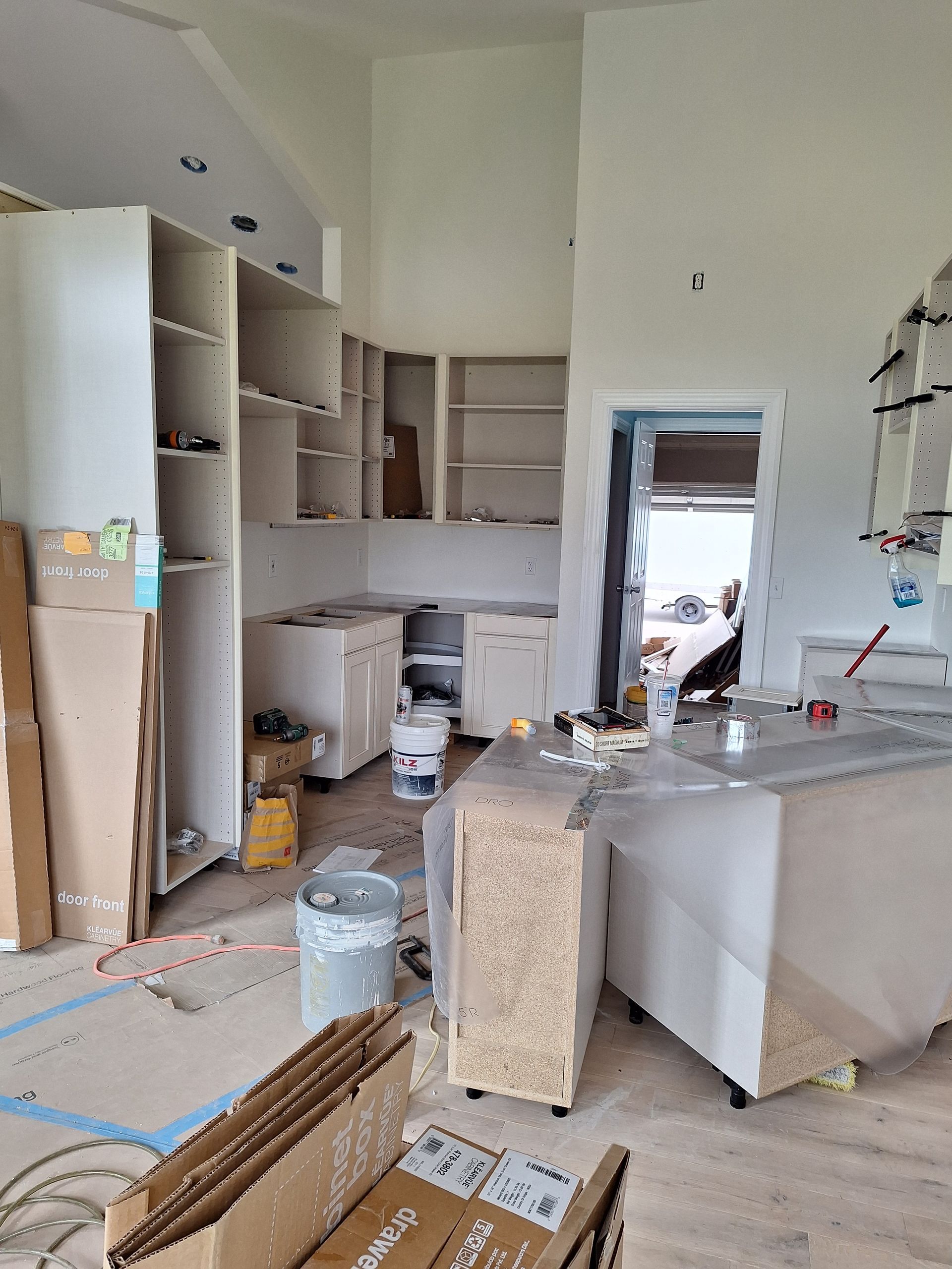 Renovated kitchen with cabinets, countertop, tools, and supplies scattered across the floor