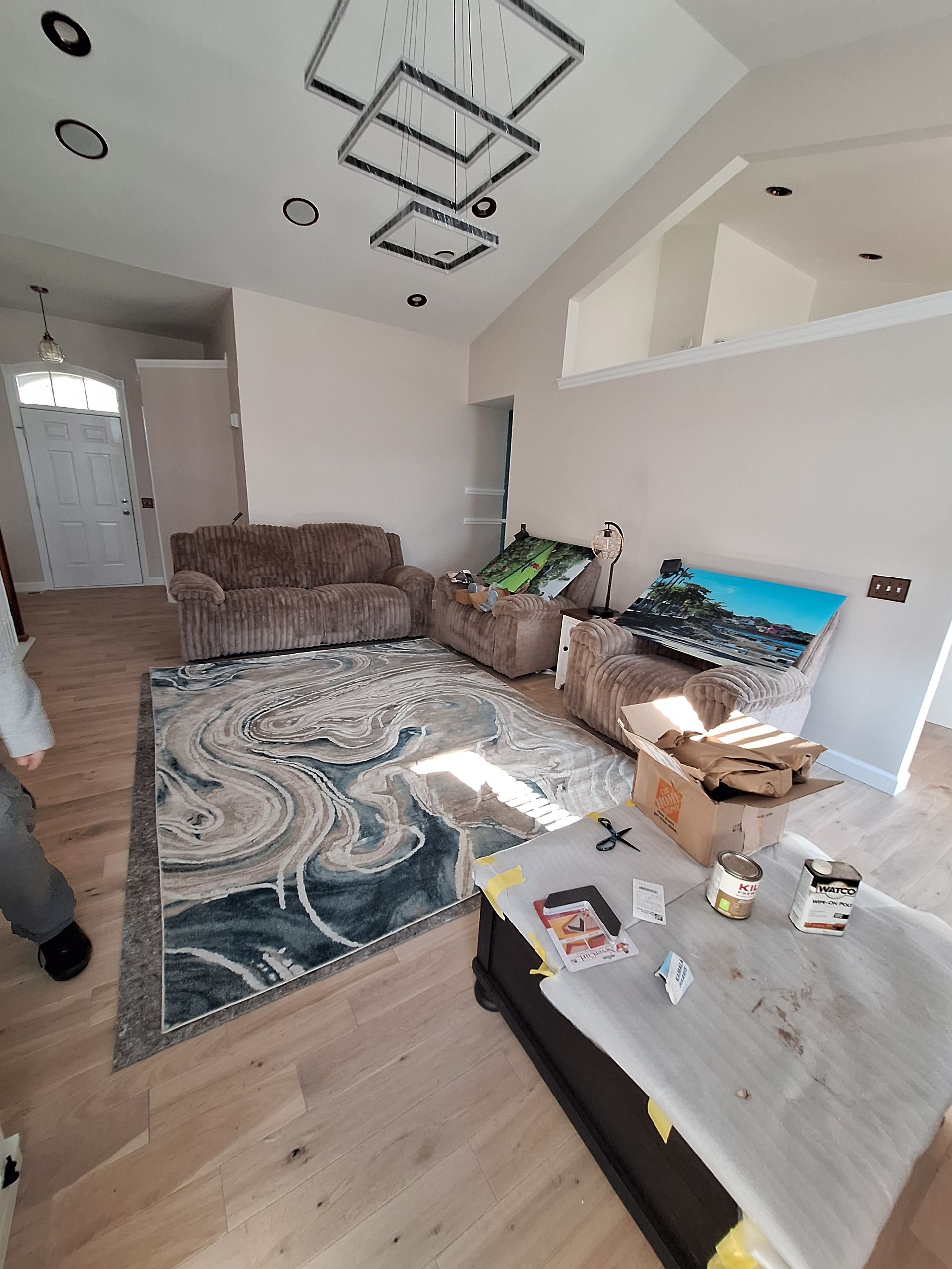Bright living room with sectional sofa, patterned rug, coffee table, and skylight windows