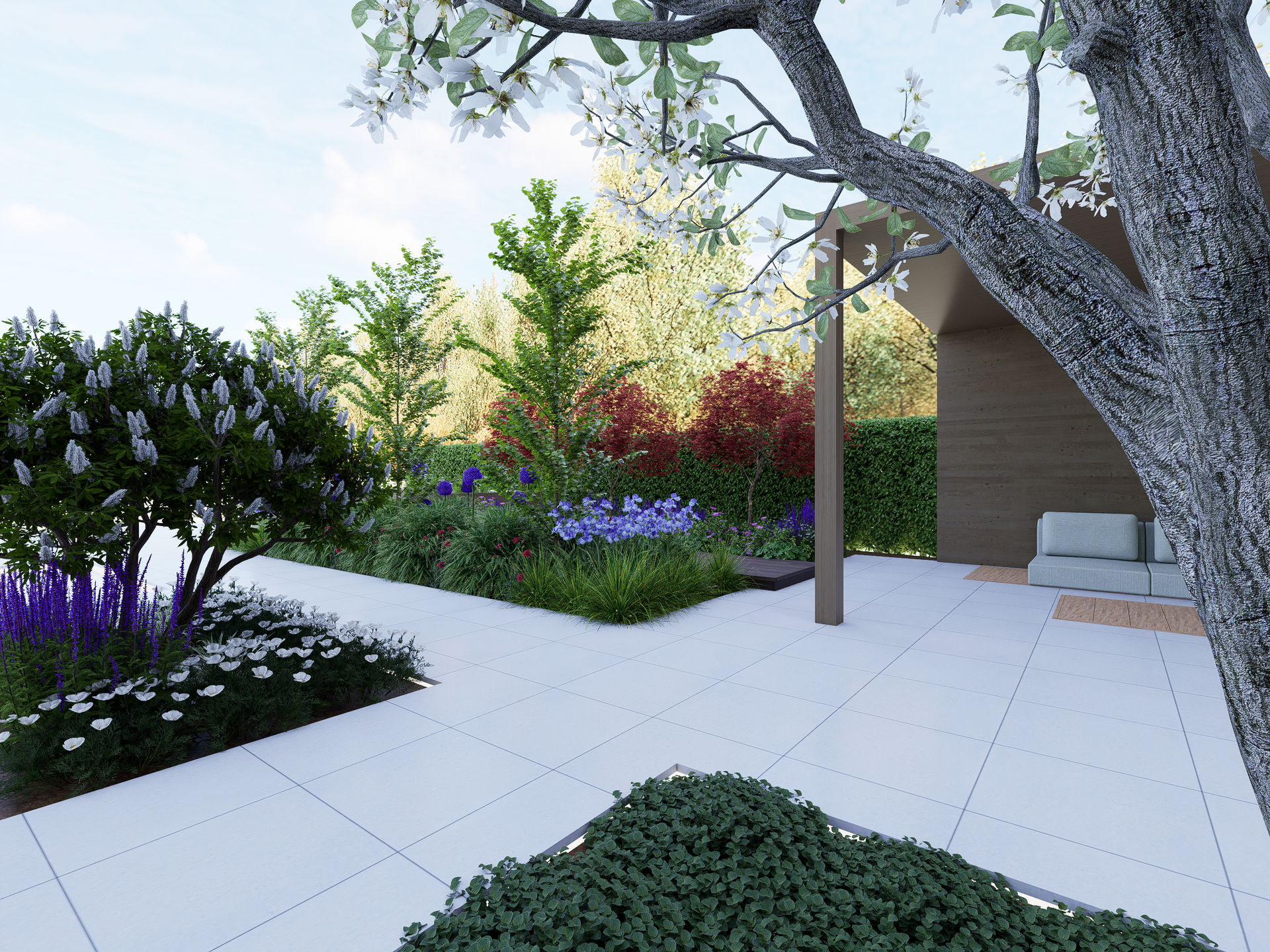 Landscaped garden with blooming trees, flower beds, and a paved patio.
