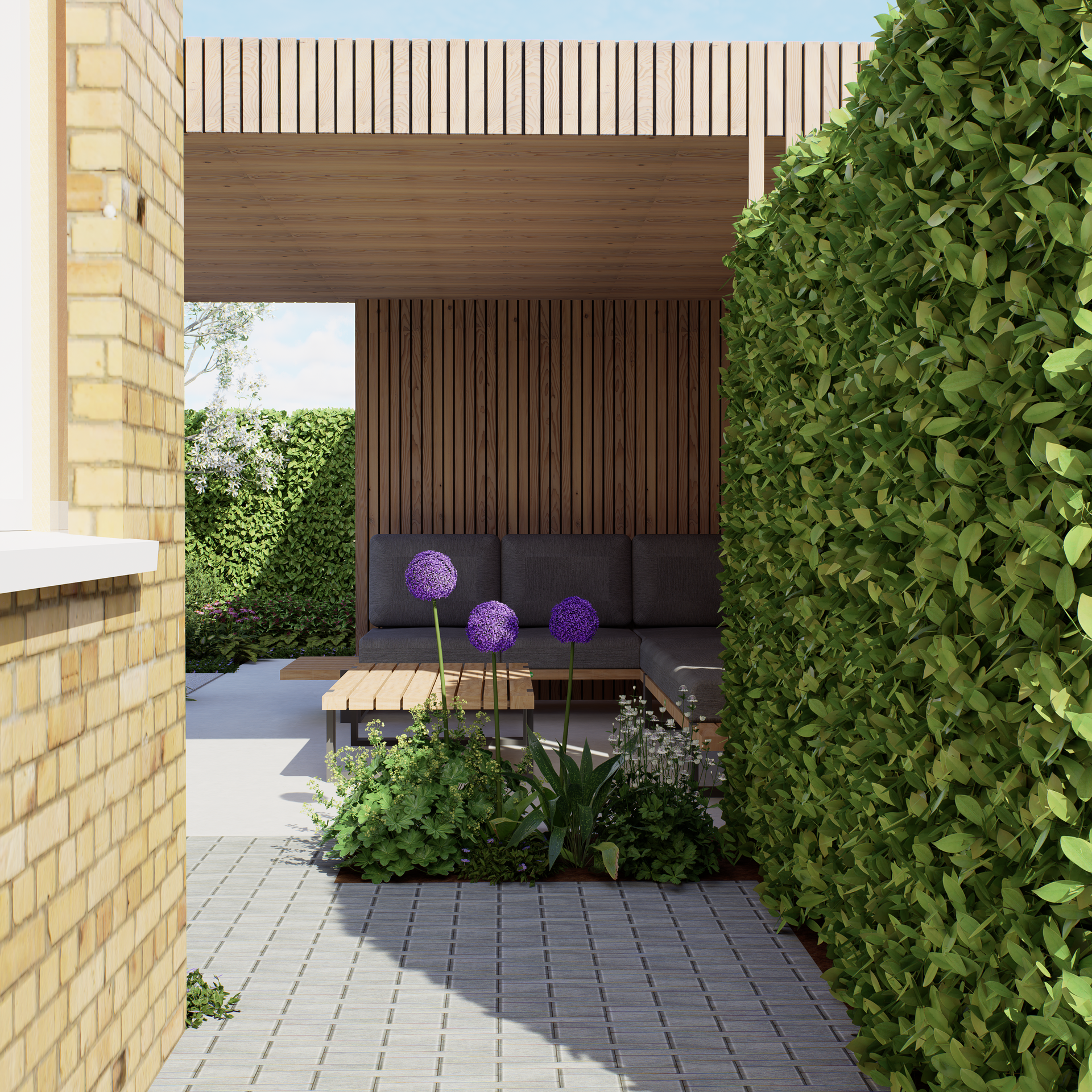 Outdoor lounge area: wooden pergola, gray sofa, purple allium flowers, brick path, and green hedge.