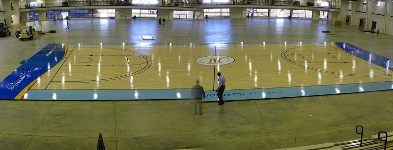 A man is standing on a basketball court with the word texas on it.