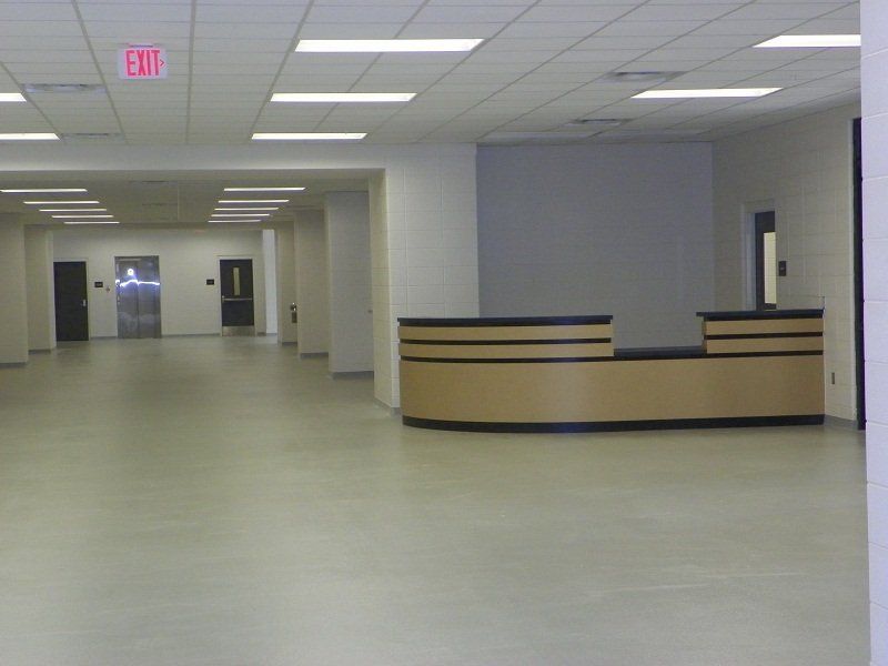 An empty hallway with a red exit sign on the ceiling