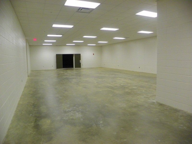 A large empty room with white walls and a concrete floor