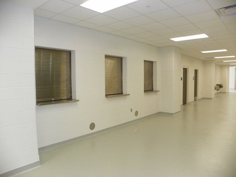 An empty hallway with a row of windows on the wall.