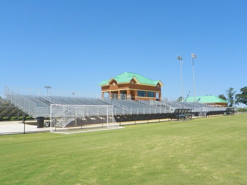 A soccer field with a stadium in the background