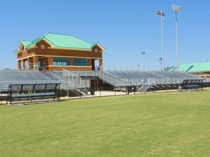 A stadium with bleachers and a building with a green roof