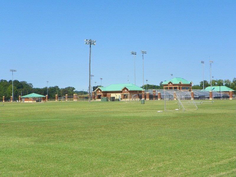A soccer field with a stadium in the background