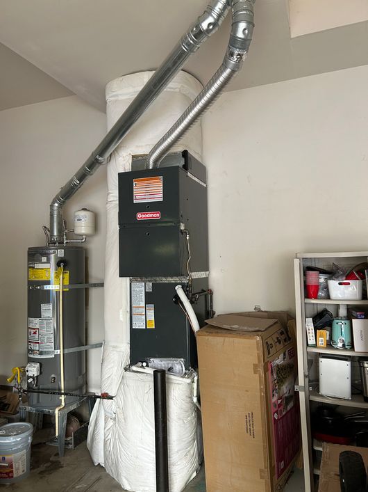 Basement utility area with furnace, vent pipes, water heater, shelves, and stored boxes