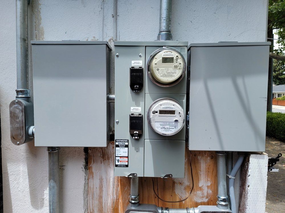 Electrical meters and circuit breakers mounted on a building exterior.