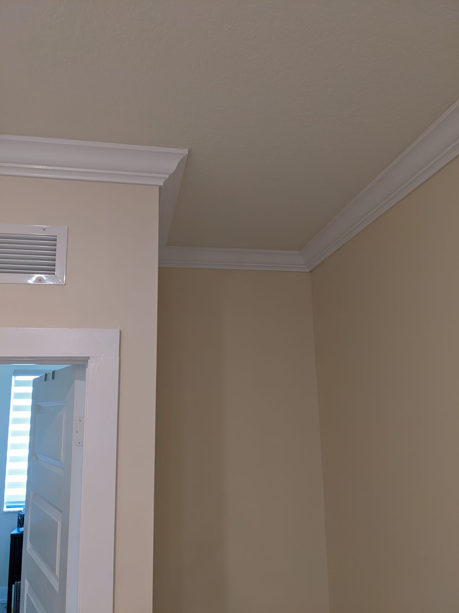 A room with beige walls and a white trim on the ceiling.