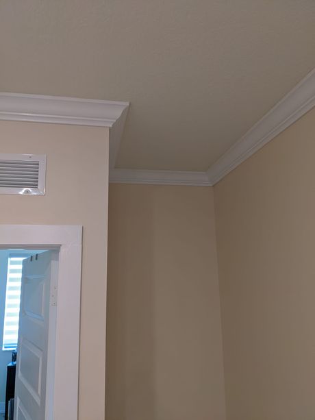 A room with beige walls and a white trim on the ceiling.
