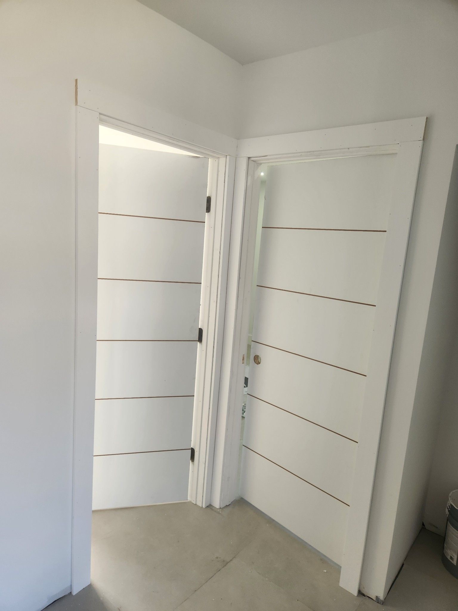 A room with a white door and a white wall