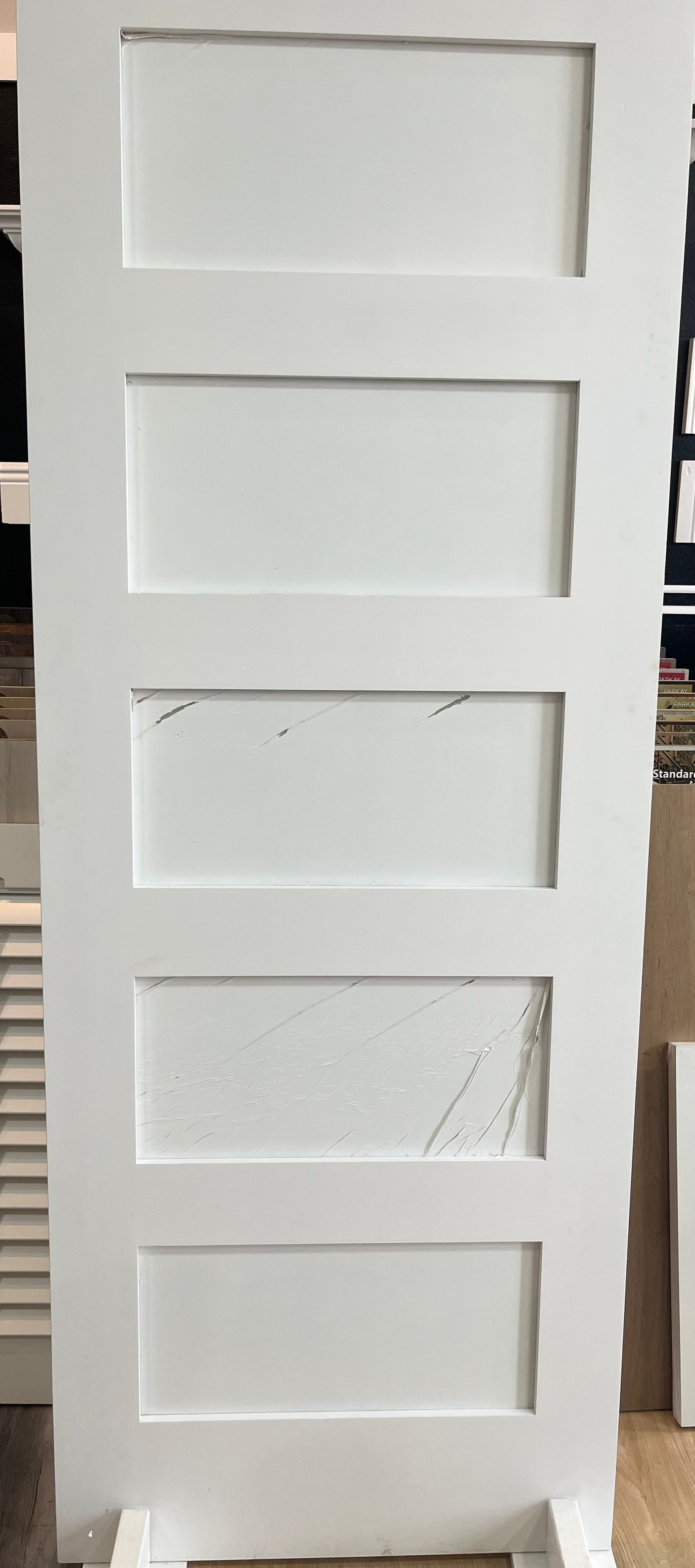 A white door is sitting on top of a wooden table.