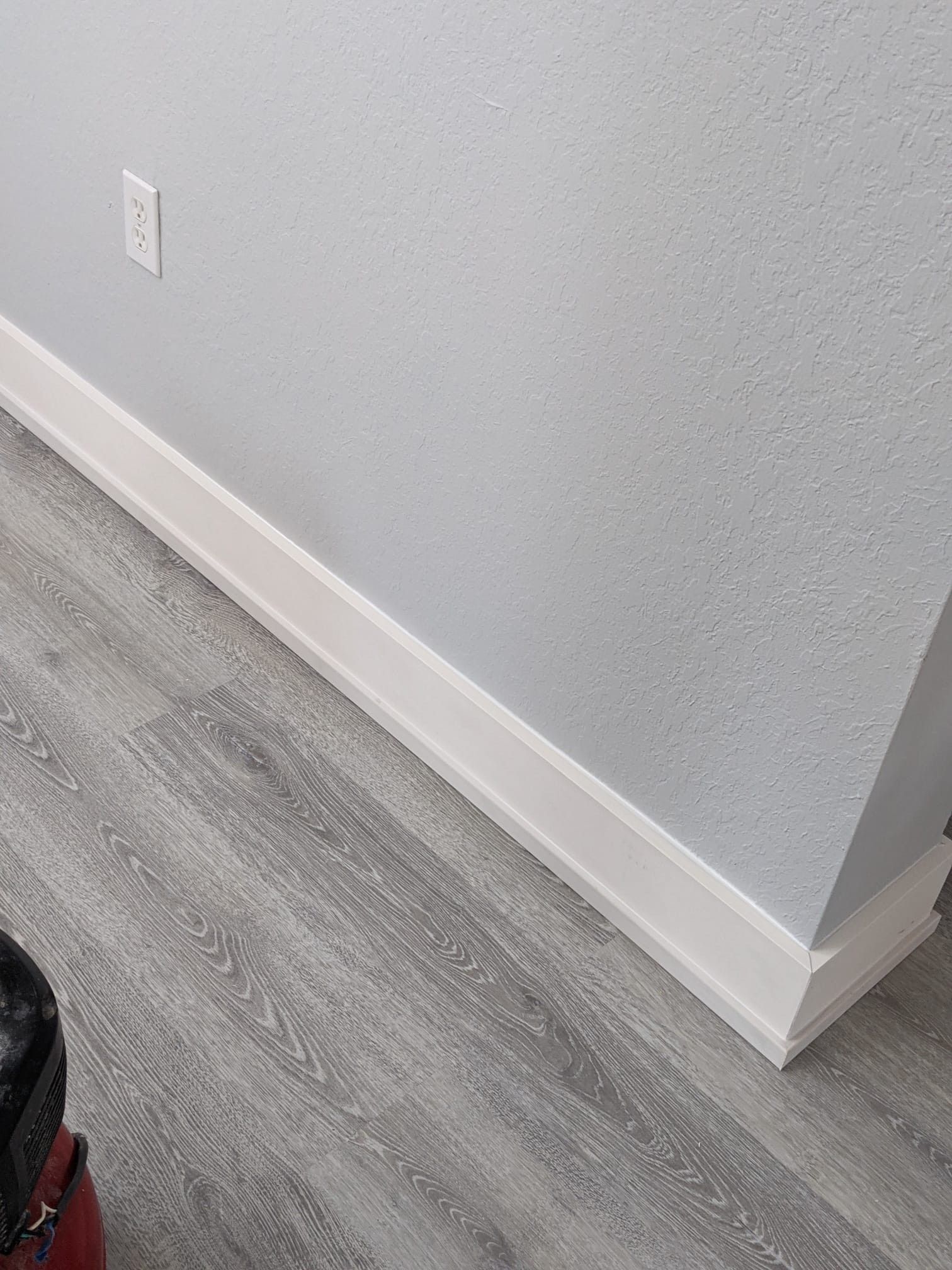 A person standing on a set of wooden stairs in a hallway